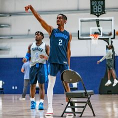 two men playing basketball in an indoor gym