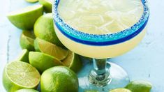 a margarita sitting on top of a table next to limes