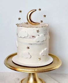 a white cake with gold stars and a crescent decoration on top, sitting on a gold platter