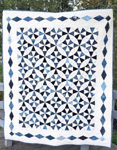 a black and white quilt on a wooden bench