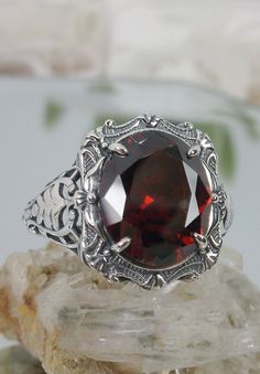 "Red Garnet Ring (Choose Garnet CZ or a Natural Red Garnet Gemstone) Beauty Design#229 MADE TO ORDER Ring Description This is a brand new stunning Art Nouveau/Victorian reproduction sterling silver filigree ring. The flawless oval-cut high-quality 5ct Red Garnet gemstone is 12mm by 10mm (just shy of 3/8\" inch) in dimension. (Choose between a Red Garnet CZ or a Natural 5ct Natural Garnet (VVS)). The ring is 5/8th of an inch (16.5mm) NS (long) on the finger. The ring and gem sit 7mm off the finge Victorian Red Oval Filigree Ring, Antique Red Oval Filigree Ring, Red Oval Filigree Ring With Intricate Design, Red Ruby Ring With Intricate Design, Red Ruby Oval Filigree Ring, Red Oval Filigree Ring For Anniversary, Red Oval Filigree Ring For Formal Occasions, Oval Ruby Filigree Ring In Red, Luxury Oval Red Ruby Filigree Ring