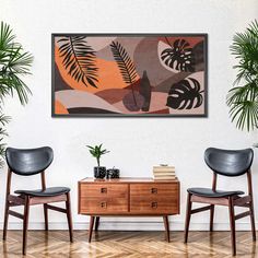 two chairs and a table in front of a painting on the wall with palm leaves