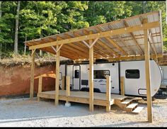 an rv is parked under a wooden structure