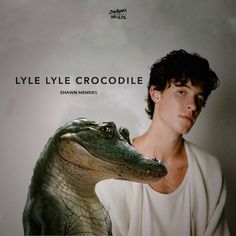 a young man holding an alligator in front of his face with the caption lylie lyle crocodiledlee