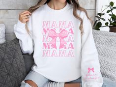 Wrap your mom in love with our custom mama coquette sweatshirt, boasting a sweet "mama" repeated 5 times and a large pink bow with polka dots. Personalize the left sleeve with her kids' names for a thoughtful touch. With long sleeves and a cozy crewneck, this pullover is the perfect Mother's Day gift for the girlie girl mom who adores pink bows and cozy style. The Gildan 18000 long-sleeve sweatshirt offers a relaxed, classic fit with unisex sizing--check the size chart for the perfect match. Cra Cute Customizable White Sweatshirt, Cute White Customizable Sweatshirt, Cute White Sweatshirt For Mother's Day, Coquette Sweatshirt, Mama Sweater, Bow Coquette, Girlie Girl, Aesthetic Gift, Soft Girl Aesthetic