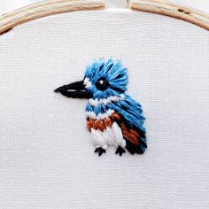 a blue and white bird embroidered onto a piece of cloth