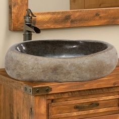 a bathroom sink sitting on top of a wooden cabinet next to a wall mounted mirror