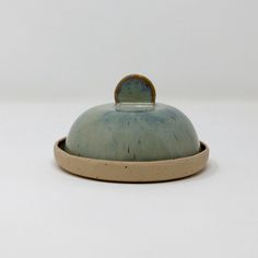 a ceramic covered dish sitting on top of a white table