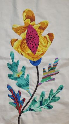 an embroidered piece of cloth with flowers and leaves painted on it's side,