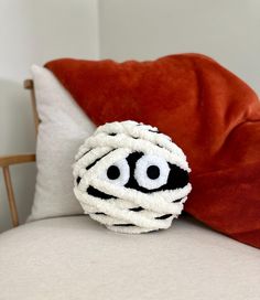 a close up of a pillow on a bed with an eyeball in the middle