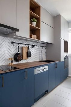 a kitchen with blue cabinets and wooden counter tops, white tile backsplash and open shelving