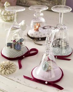 three wine glasses are sitting on a table with ribbons and bows around the glass holders