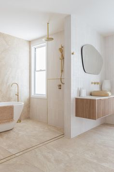 a bathroom with a sink, mirror and bathtub next to a window on the wall