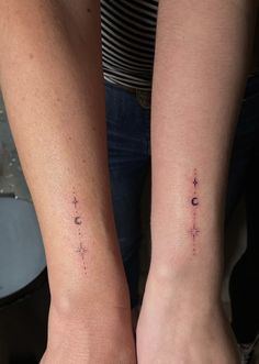 two people with matching tattoos on their arms, one is holding the other's hand