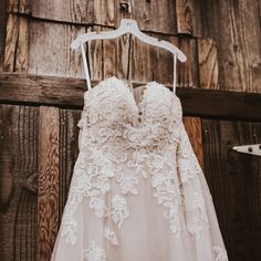 a wedding dress hanging on a wooden wall