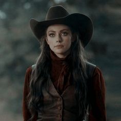 a woman with long hair wearing a cowboy hat