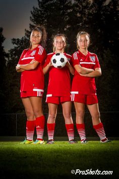 three female soccer players are posing for a photo