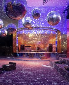 disco balls are hanging from the ceiling in front of a stage