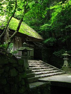 an old building in the woods with steps leading up to it and a lantern on top