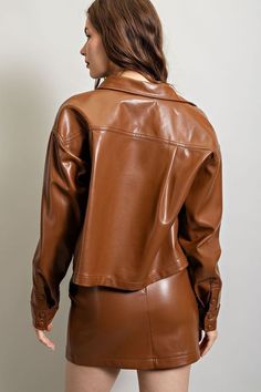 Pleather long sleeve jacket featuring a cropped length, a button down front, one chest pocket, buttoned cuffs and a collared neckline. Model is 5'8" and is wearing a small.