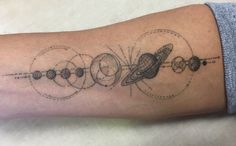 a person with a tattoo on their arm that has an image of the solar system