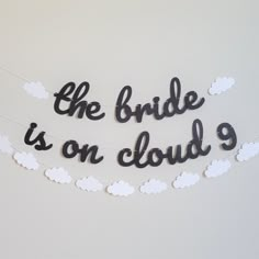 the bride is on cloud 9 sign hanging from a string with black and white clouds