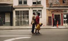 two men are crossing the street on their skateboards