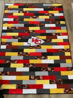 a quilt made to look like it has the kansas chiefs on it and is sitting on top of a wooden floor