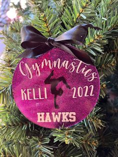 a personalized ornament hanging from a christmas tree with a ribbon on it