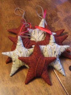 four red and white star ornaments on a wooden floor