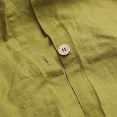 a button that is on the side of a green shirt with buttons attached to it