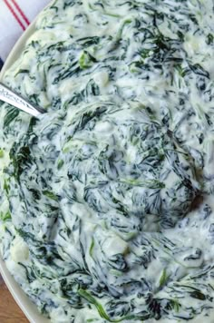 spinach dip in a white bowl with a spoon