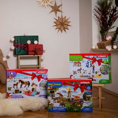 three christmas boxes sitting on the floor in front of a teddy bear and other toys