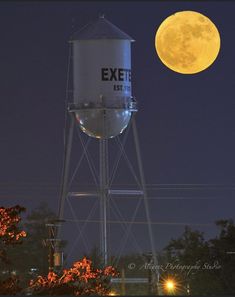 a water tower with the moon in the background