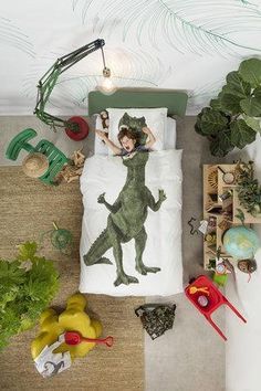 a child's bed with an image of a dinosaur printed on the comforter