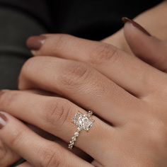 a woman's hand with a diamond ring on it