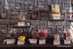 there is a table with candy and candies on it in front of a brick wall