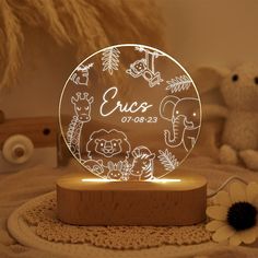 a personalized glass night light with animals on it and a flower in the foreground