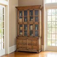 an old wooden bookcase with glass doors in a living room