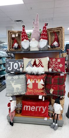 christmas pillows and santa hats on display in a store