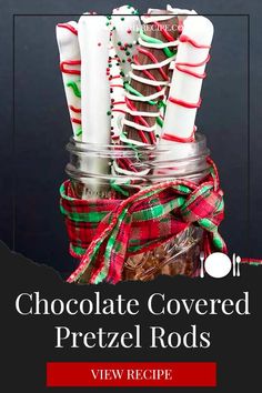 chocolate covered pretzel rods in a mason jar with red and green plaid ribbon