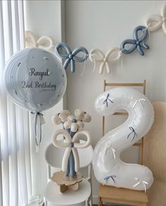 balloons and decorations are arranged in the corner of a room with a balloon shaped number 2