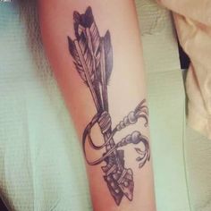 a tattoo on the arm of a woman with an arrow and two arrows in it