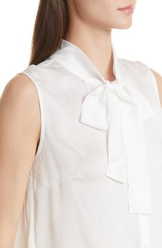 A tie detail at the neckline provides a refined finish for this woven sleeveless blouse. Ties at neck Sleeveless 100% polyester Hand wash, line dry Imported Feminine Silk Sleeveless Tank Top, Elegant Sleeveless Spring Blouse, Elegant Spring Tank Top With Bow, Elegant Sleeveless Tie-back Blouse, Elegant Sleeveless Tie Back Blouse, Elegant Bow Tank Top For Spring, Elegant Summer Blouse With Bow, Sleeveless Silk Tops, Elegant Sleeveless Viscose Blouse