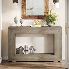 a console table with an animal figurine on top and a mirror above it