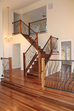 a stair case in an empty house with wood floors and railings on the sides