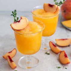 two glasses filled with orange juice and sliced peaches