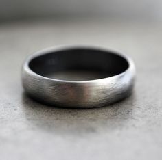 a close up of a wedding ring on a gray surface with no one in it