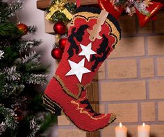 a christmas stocking hanging from a fireplace next to a lit candle and a decorated tree