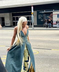 a woman walking down the street in a dress